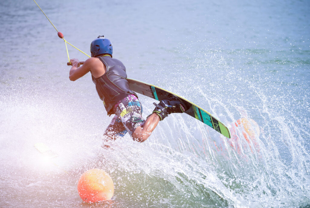 wakeboarder making tricks on the sea. wakeboarding. water sports on the beach.